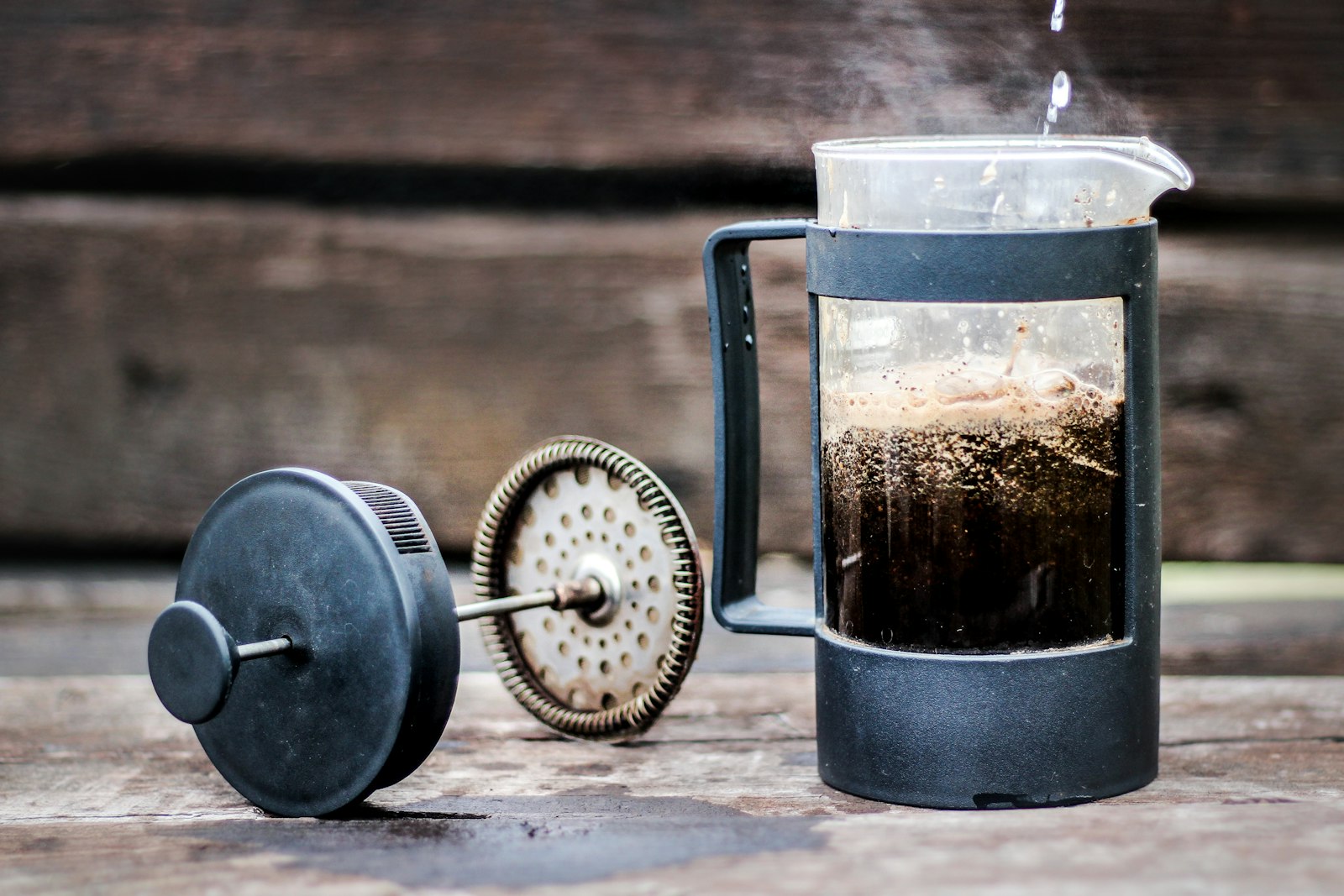French press coffee maker on a rustic wooden surface