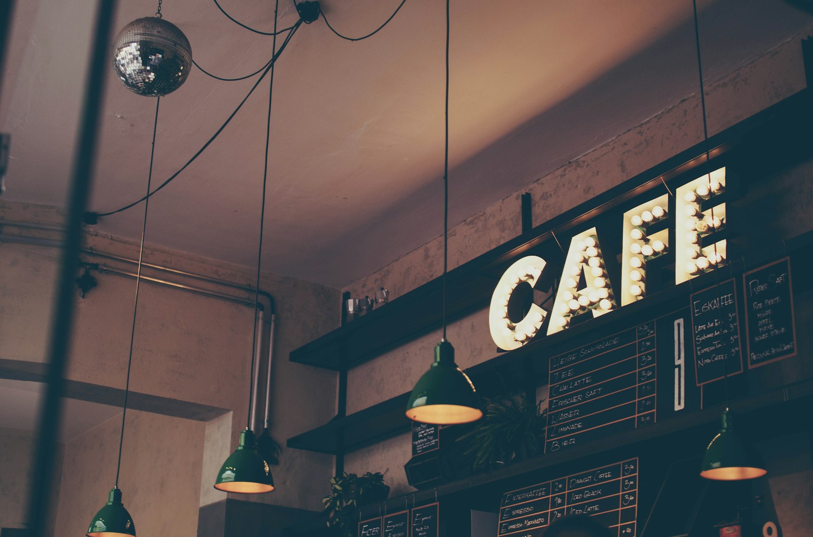 Café interior with an illuminated cafe sign and warm pendant lamps