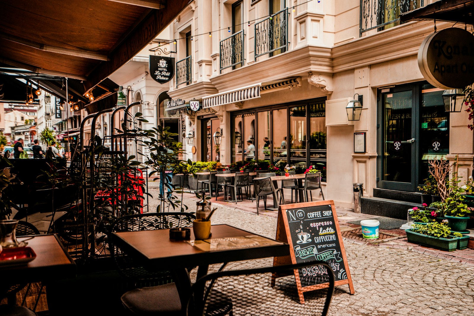 Outdoor café seating on a warm European street at golden hour